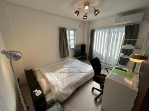a bedroom with a bed and a desk with a lamp at SABBATH uzumaza 103 in Kyoto