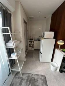 a small kitchen with a refrigerator and a microwave at SABBATH uzumaza 103 in Kyoto