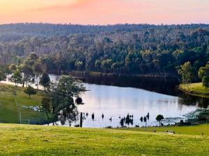 une vue d'un lac avec des arbres en arrière-plan dans l'établissement Mingara Park Cottage, à Scotsburn