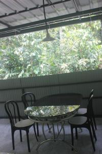 a glass table and chairs on a patio at Ferns n' Falls in Chinnakanal +10 photos