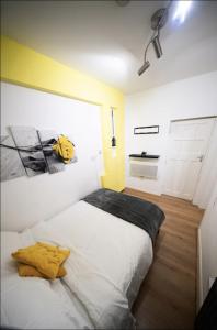 a bedroom with a large white bed with a yellow pillow at City Centre 1bed w free parking in Birmingham