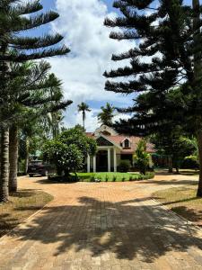 a house with palm trees in front of a driveway at The Palmyra Estate - by Cocoon, A Luxury Party Villa near Varkala in Paravūr