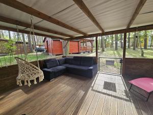 a screened in porch with a couch and a swing at Domek letniskowy nr 16 - jezioro Głębokie in Międzyrzecz