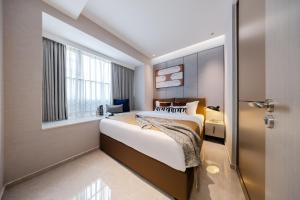 Un pat sau paturi într-o cameră la Shenzhen Gangxiahui Executive Apartment Futian Convention and Exhibition Center Branch