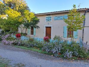 a house with a bunch of flowers in front of it at Gite le nid du canal in La Celle-sous-Gouzon