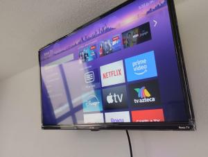 a flat screen tv sitting on a wall at Alas Host San Ale in Momoxpan