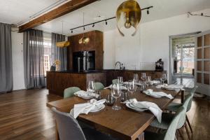 Un comedor con mesa y sillas de madera. en Künni Villa, saun ja mullivann, en Viljandi