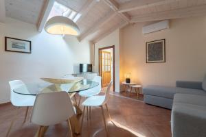 a living room with a glass table and white chairs at La Nassa in Alghero