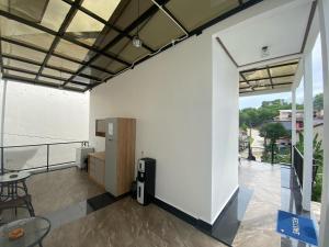 ein Raum mit einer weißen Wand und einem Tisch und Stühlen in der Unterkunft EMWEKA Residence Balikpapan in Balikpapan