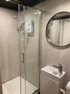 a bathroom with a shower with a sink and a mirror at Boars Head in Louth +24 photos