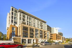 an apartment building with cars parked in a parking lot at Castle Hill Modern 2BR Apartment in Castle Hill