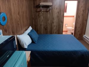 una camera con letto blu e un bagno di Crawford Motel a Springfield