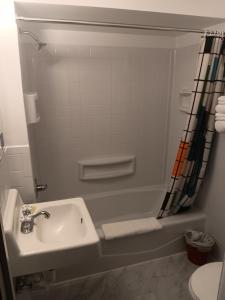 un bagno con lavandino e vasca da bagno di Crawford Motel a Springfield