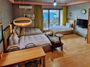 a hotel room with two beds and a television at OROJEJU in Seogwipo +84 photos