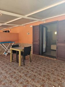 a room with a table and chairs and a bedroom at La Rosa dei Venti B&B in Chia