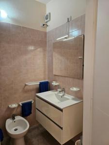 a bathroom with a sink and a toilet at La Rosa dei Venti B&B in Chia