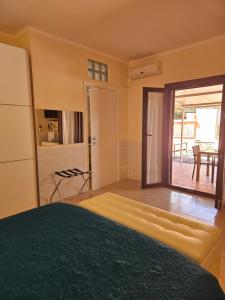 a bedroom with a bed and a door to a patio at La Rosa dei Venti B&B in Chia