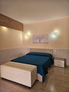 a bedroom with a large bed with a blue blanket at La Rosa dei Venti B&B in Chia