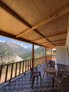 a room with a balcony with chairs and a table at Apple Crest Homestay in Harsil