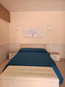a bedroom with a large bed with a tree on the wall at La Rosa dei Venti B&B in Chia