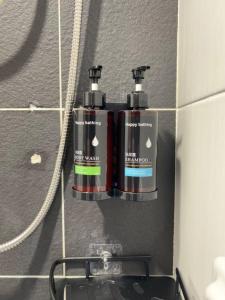 two bottles ofodorizers on the wall of a bathroom at G Home 3 - Ipoh City Centre Majestic 2R2B in Ipoh