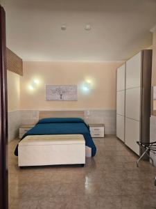 a bedroom with a bed with a blue blanket at La Rosa dei Venti B&B in Chia