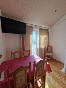 een eetkamer met een tafel en stoelen en een raam bij Apartments Lucija-Klara in Brodarica