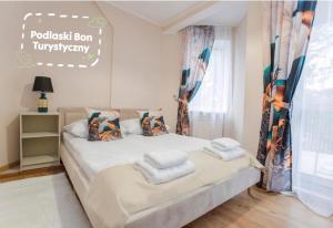a bedroom with a bed with towels on it at Willa Marcella in Białystok