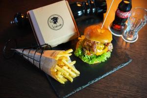 a sandwich and french fries on a table with a drink at Hotel Restaurant zum Löwen in Duisburg