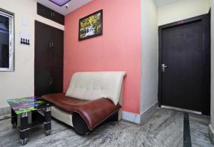 a room with a chair and a red wall at Hotel O Chinar in kolkata