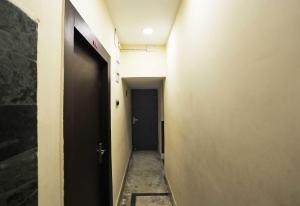 an empty hallway with a black door and a hallway sidx sidx at Hotel O Chinar in kolkata