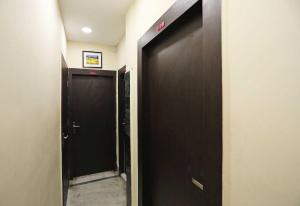 a hallway with two black doors at Hotel O Chinar in kolkata +48 photos
