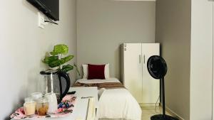 a room with a bed and a table with a desk at Maita Guest in Cape Town