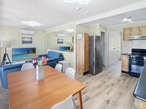 a kitchen and a living room with a table and a couch at Charming 2-Bed Apartment with Bay Views in Batemans Bay