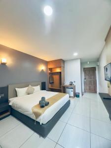 a bedroom with a large bed with a teddy bear on it at Grand Village Inn in Pantai Cenang +61 photos