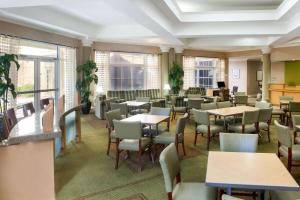a dining room with tables and chairs and windows at La Quinta by Wyndham Austin Southwest in Austin