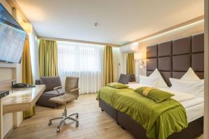 ein Hotelzimmer mit einem Bett und einem Schreibtisch in der Unterkunft Best Western Plus Hotel Füssen in Füssen