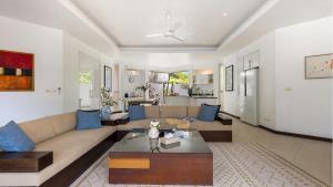 ein Wohnzimmer mit Sofa und Tisch in der Unterkunft Velaya Blue Villa at Lipa Noi in Lipa Noi