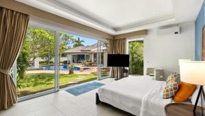 ein Schlafzimmer mit einem Bett und einem großen Fenster in der Unterkunft Velaya Blue Villa at Lipa Noi in Lipa Noi