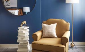 a chair in a room with a mirror and a pile of books at Graduate by Hilton Richmond in Richmond