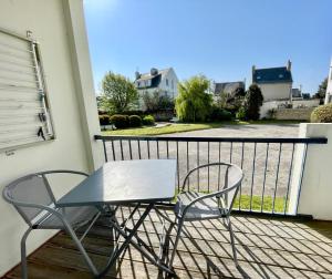 a table and two chairs on a balcony at Joli studio Rockroum in Roscoff