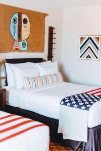 two beds in a hotel room with an american flag at Graduate by Hilton Tempe in Tempe