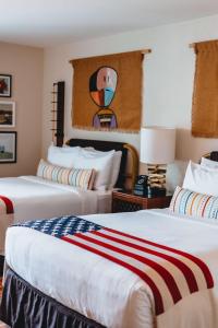 two beds in a hotel room with a painting on the wall at Graduate by Hilton Tempe in Tempe