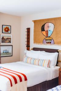 a bedroom with a bed with a painting on the wall at Graduate by Hilton Tempe in Tempe