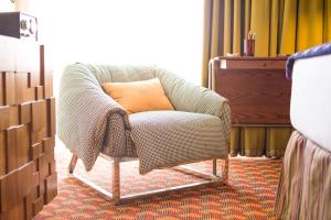 a chair with an orange pillow in a room at Graduate by Hilton Tempe in Tempe