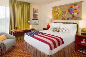 a hotel room with a large bed with an american flag blanket at Graduate by Hilton Tempe in Tempe