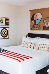 a bedroom with a white bed with a painting on the wall at Graduate by Hilton Tempe in Tempe
