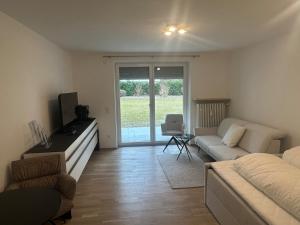 a living room with a couch and a tv at Neues Appartement Helena in Kreuth
