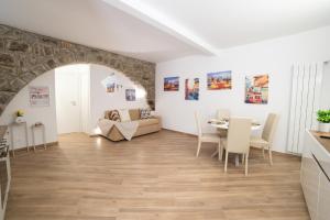 a living room and dining room with a table and chairs at L'Archetto di Romeo in Montefiascone +6 photos