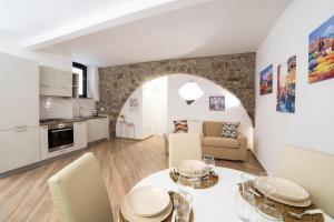 a kitchen and living room with a table and chairs at L'Archetto di Romeo in Montefiascone